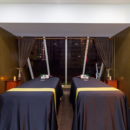 Torre Monserrate Bogota Exterior photo The photo shows a spa treatment room featuring two massage tables covered with dark blue cloths. Each table is set with small towels or accessories on top. The walls are painted a deep green, and large windows with curtains allow for natural light. T