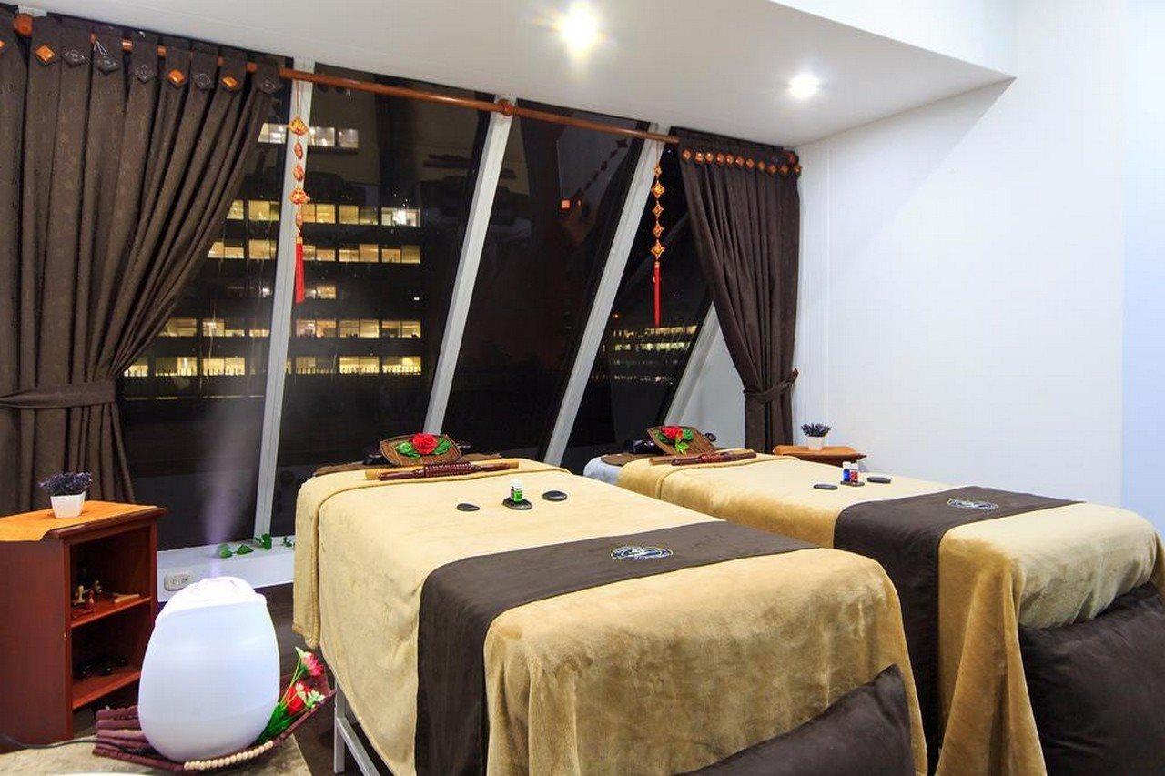 Torre Monserrate Bogota Exterior photo The photo shows a spa or massage room with two massage tables, each covered with soft, beige blankets. The room features large windows that provide a view of the city skyline, suggesting a higher floor location. Soft lighting illuminates the space, c
