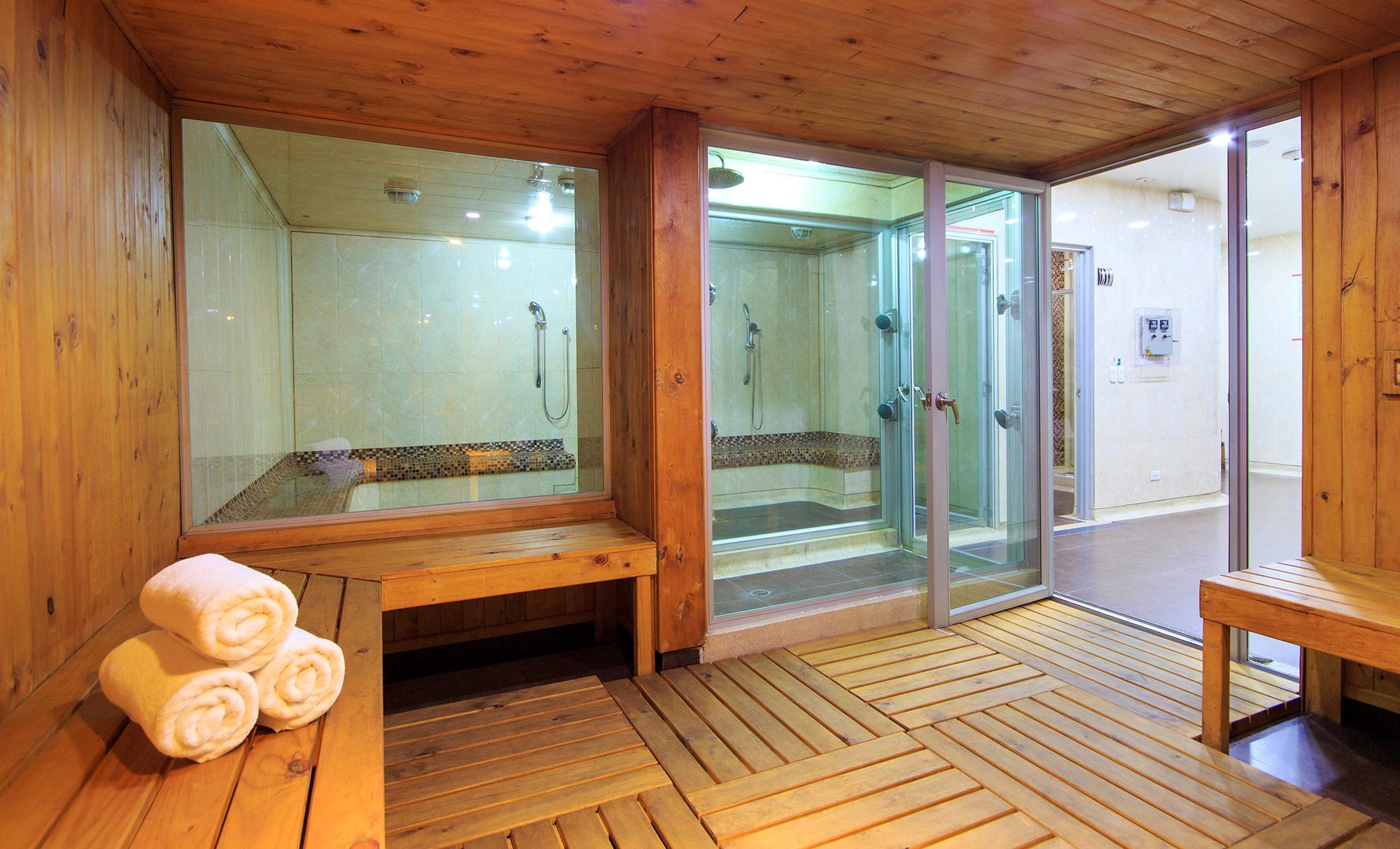 Torre Monserrate Bogota Exterior photo The photo shows a spa or sauna area. There are wooden benches and a wooden floor, creating a warm and natural atmosphere. In the background, there are two glass-enclosed shower stalls. One area appears to have a small hot tub or relaxation pool. Neat