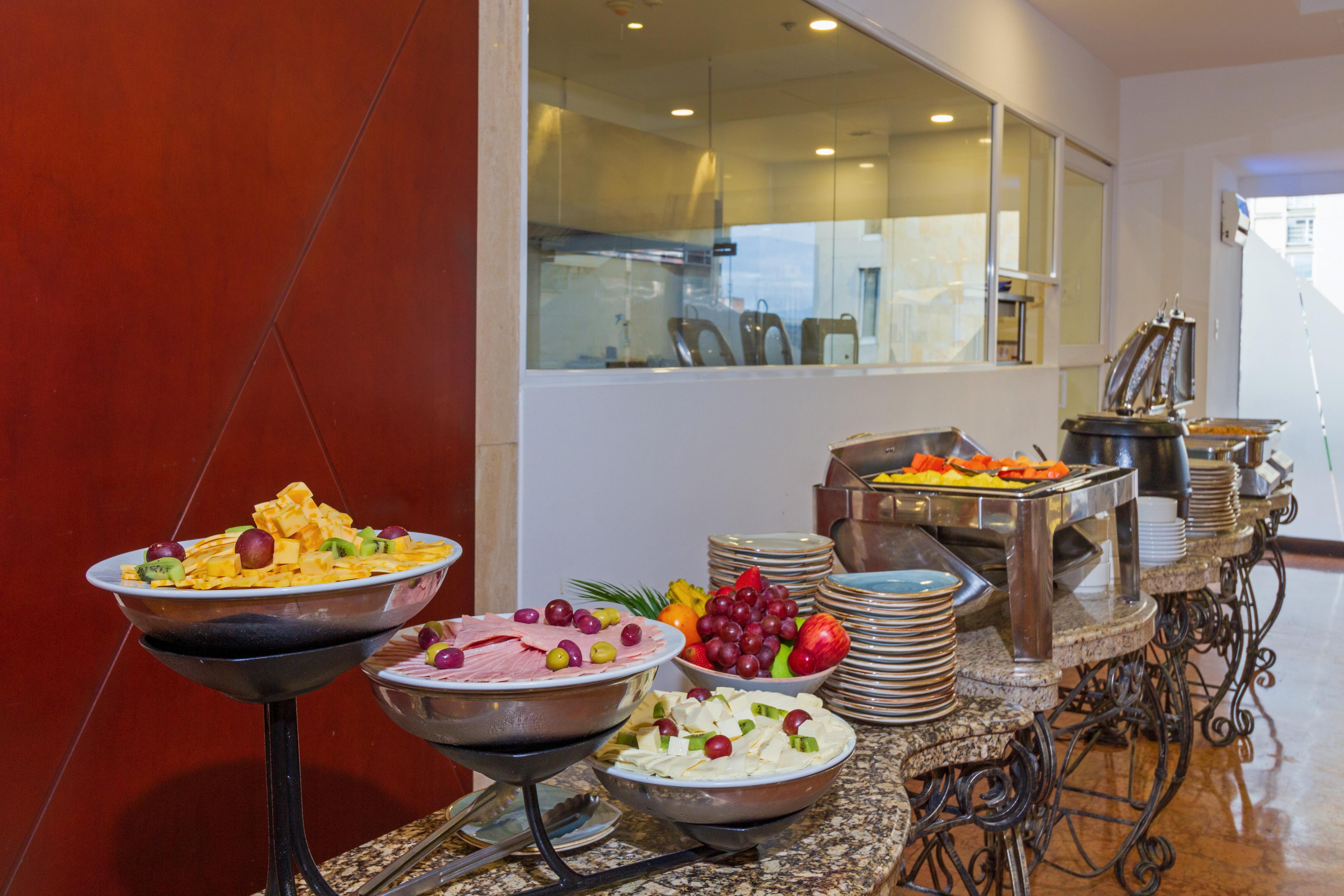 Torre Monserrate Bogota Exterior photo The photo shows a buffet setup featuring a variety of food items. On the left, there are multiple bowls of colorful salads, including fruits and vegetables. In the center, there are bowls with different types of dishes, likely including some creamy o