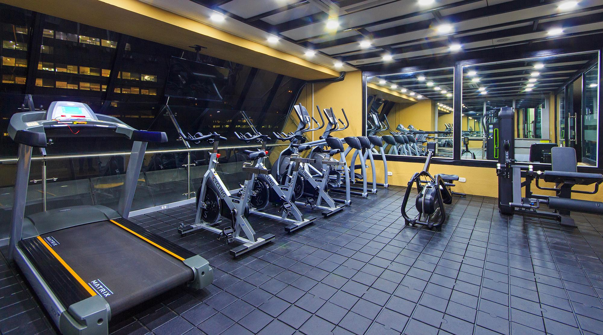 Torre Monserrate Bogota Exterior photo The photo shows a modern gym interior with several exercise machines. On one side, there is a treadmill. Along the wall, there are multiple stationary bikes and elliptical machines, arranged neatly. The gym has large windows that let in natural light